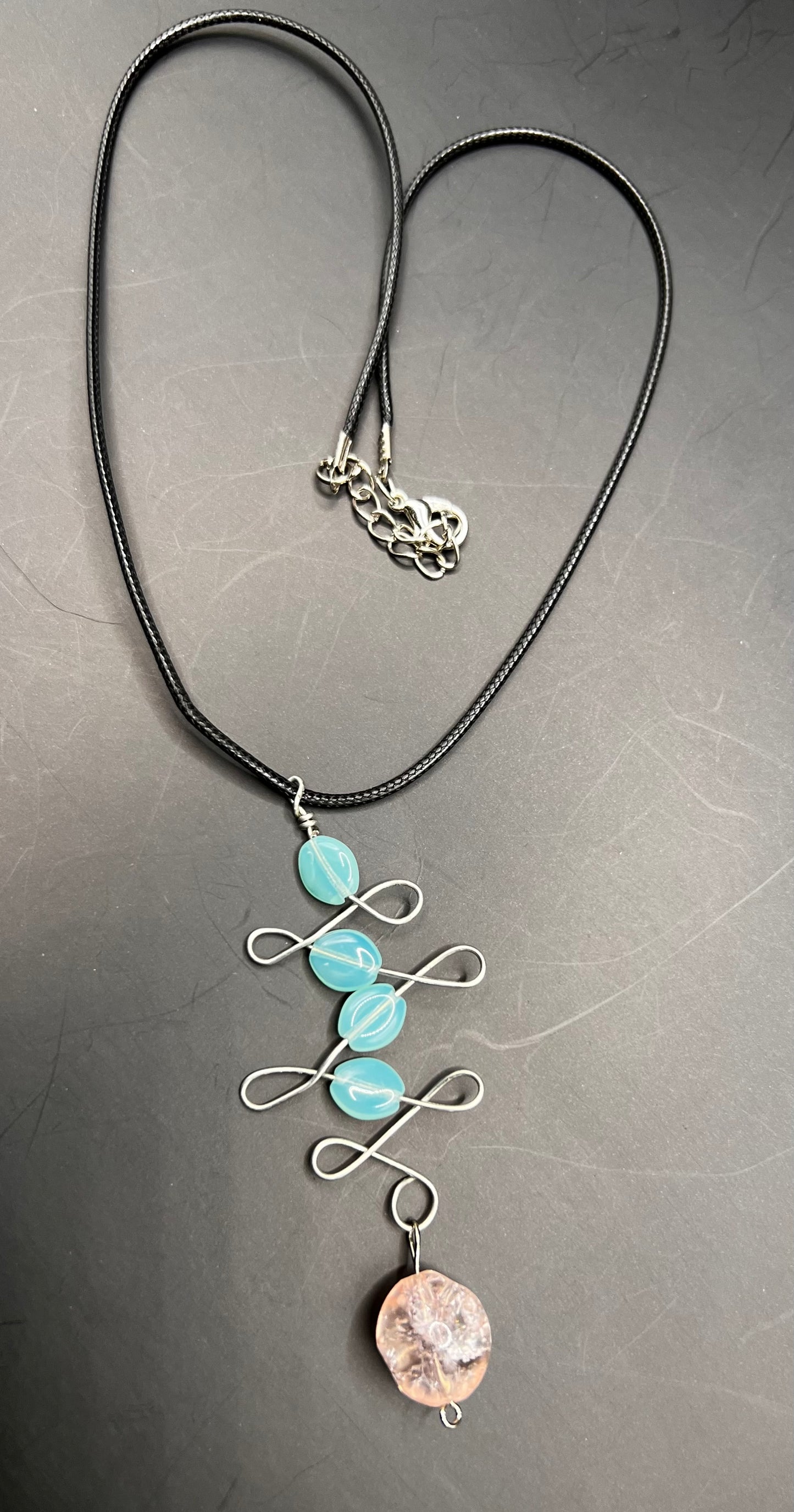 Black chord necklace with silver design with aqua and pink beads