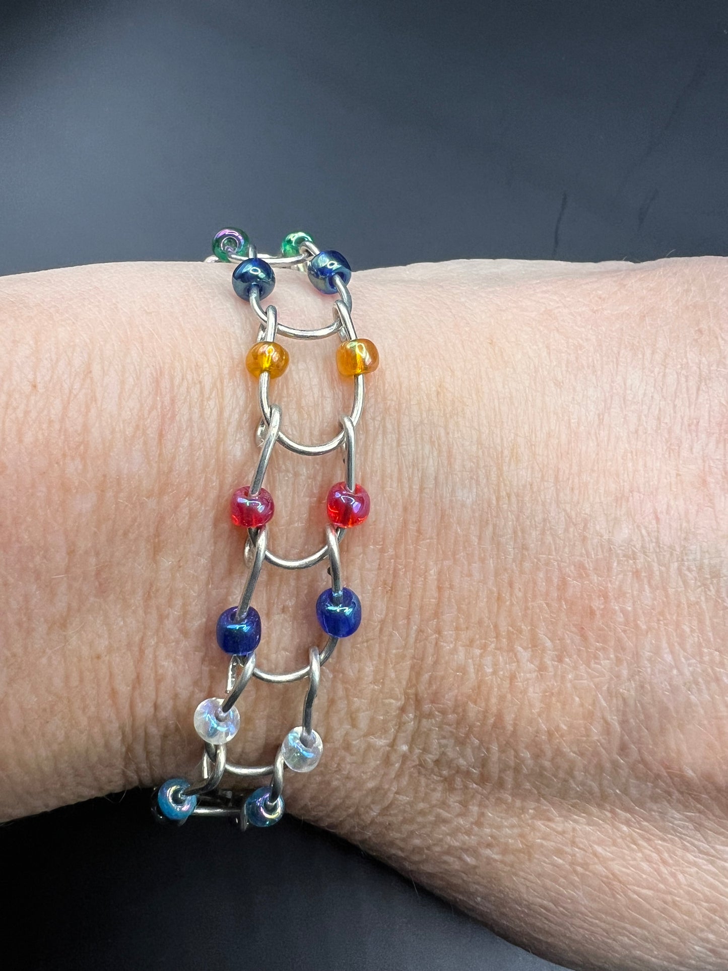 Silver bracelet with horseshoe shaped links with multicolored beads