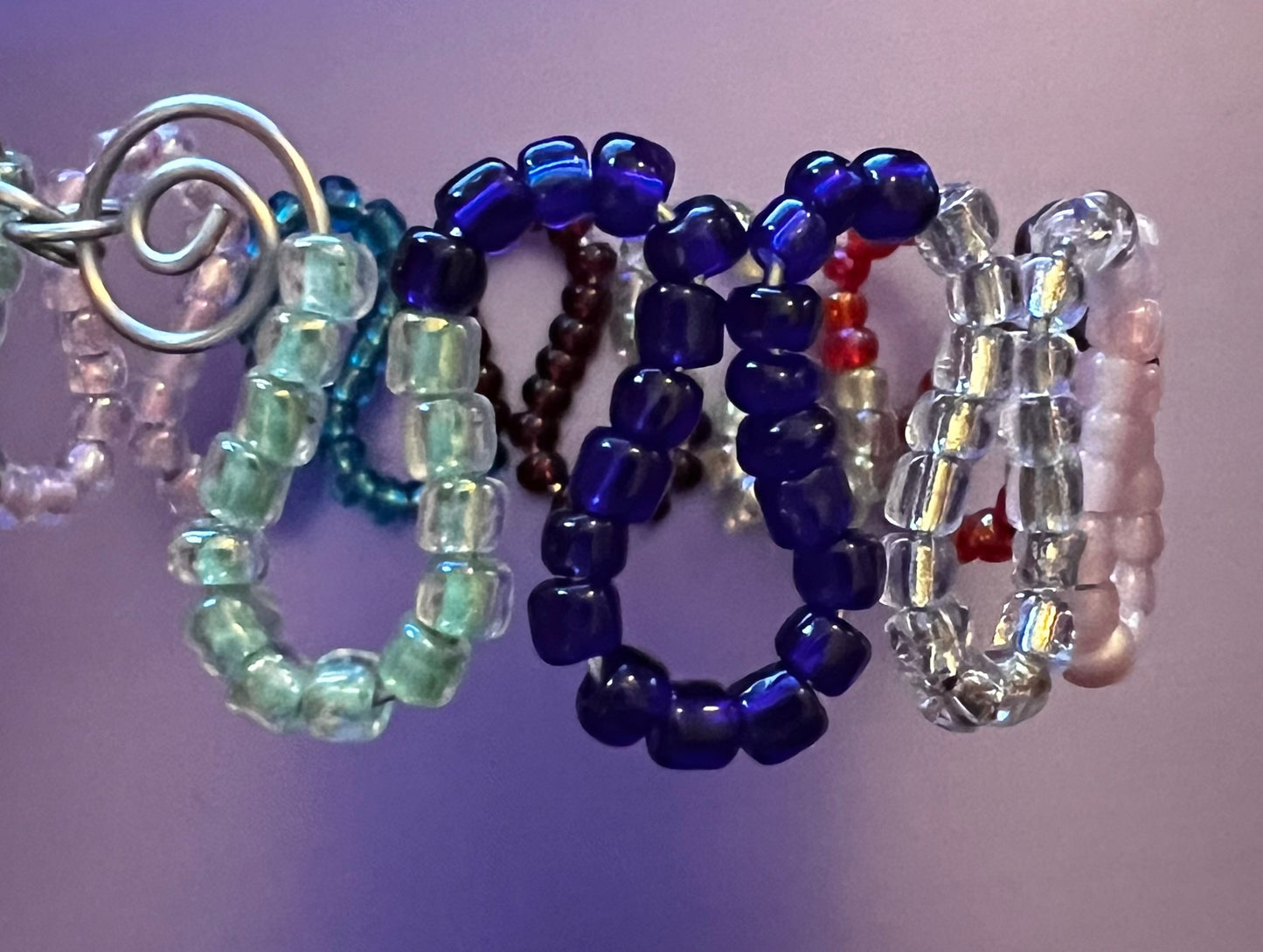 Multicolored loops w/ seed beads & coils. Cuffed silver bracelet