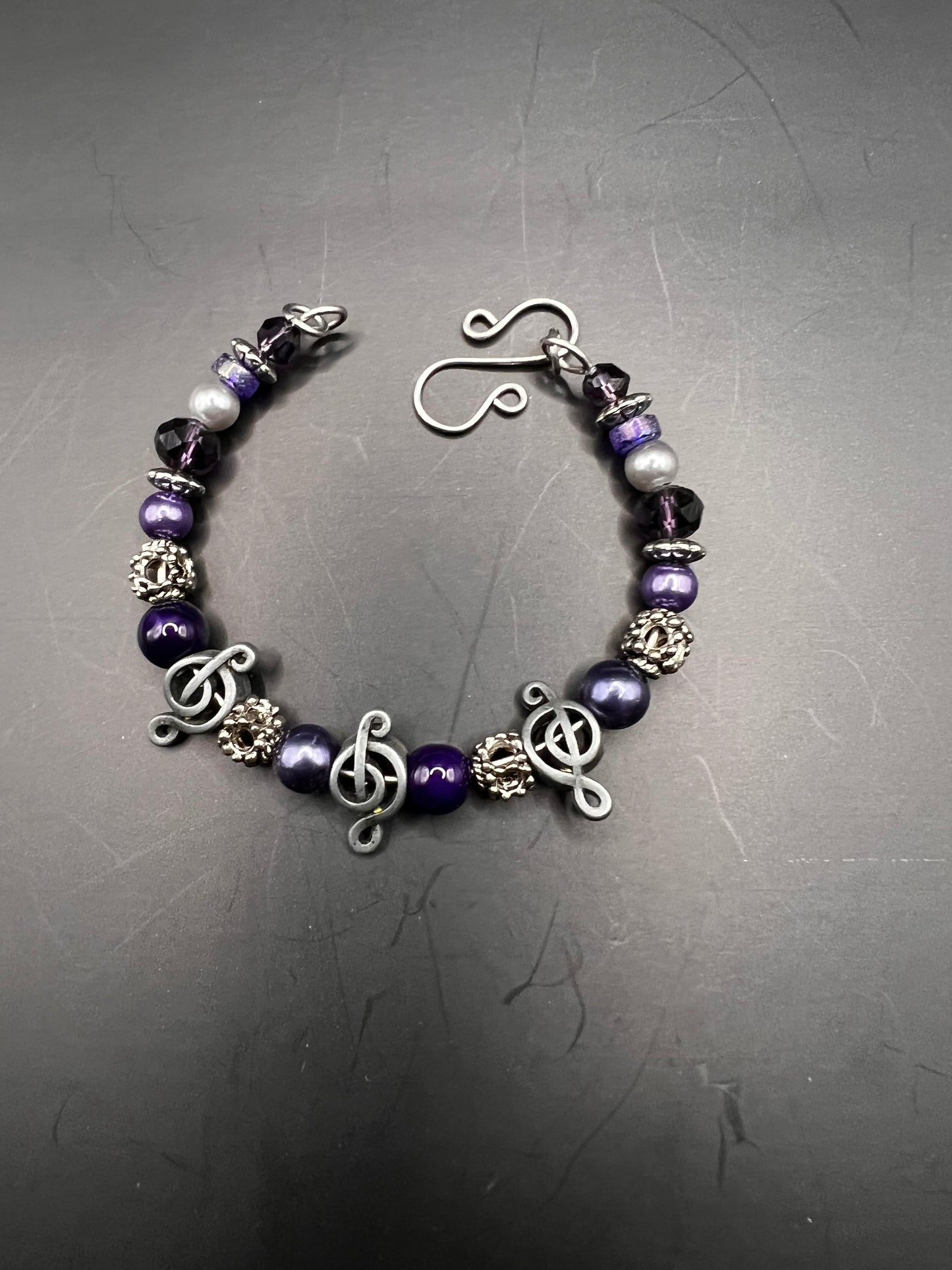 Silver cuff bracelet w/ purple beads & treble clef notes