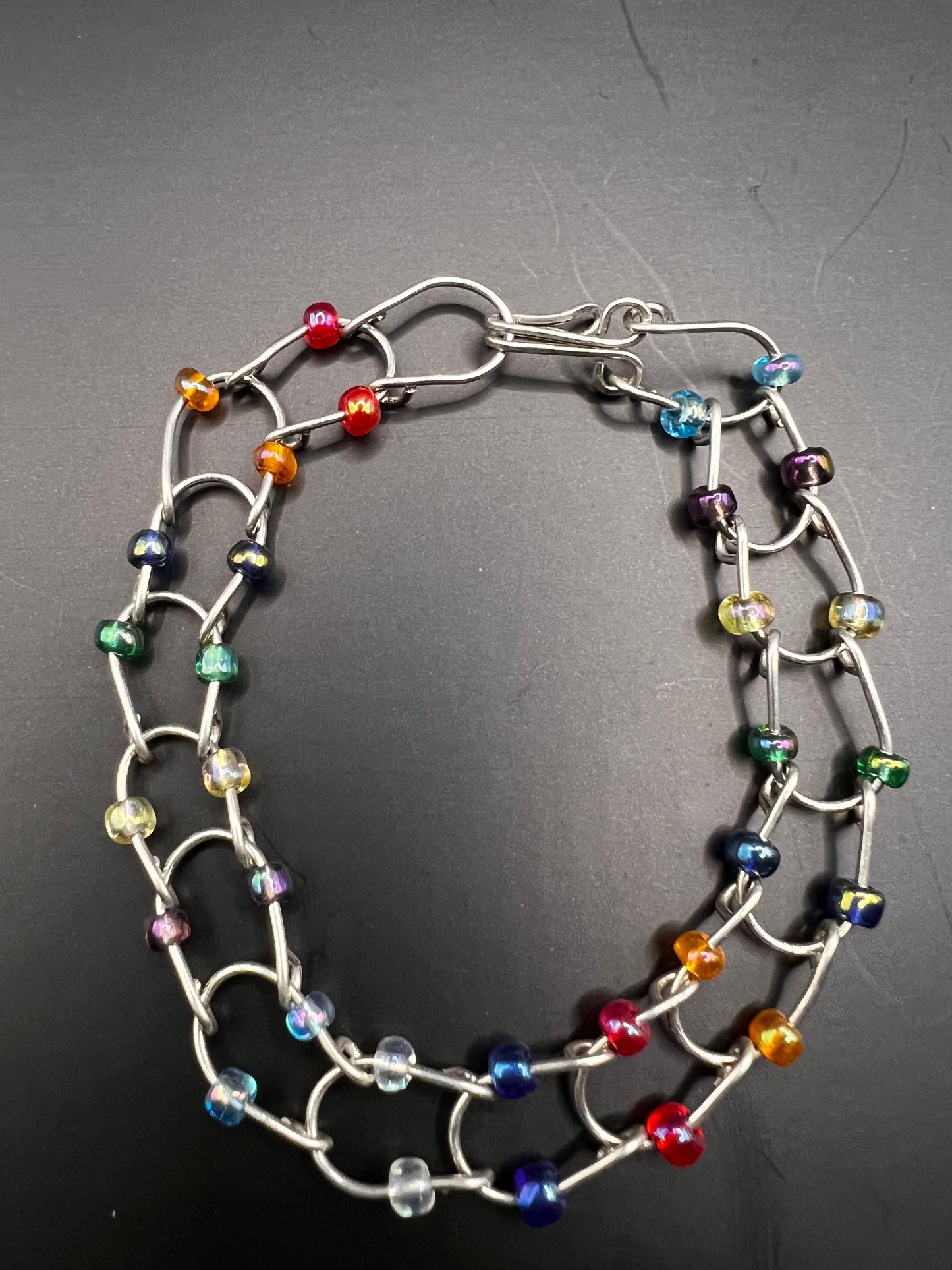 Silver bracelet with horseshoe shaped links with multicolored beads