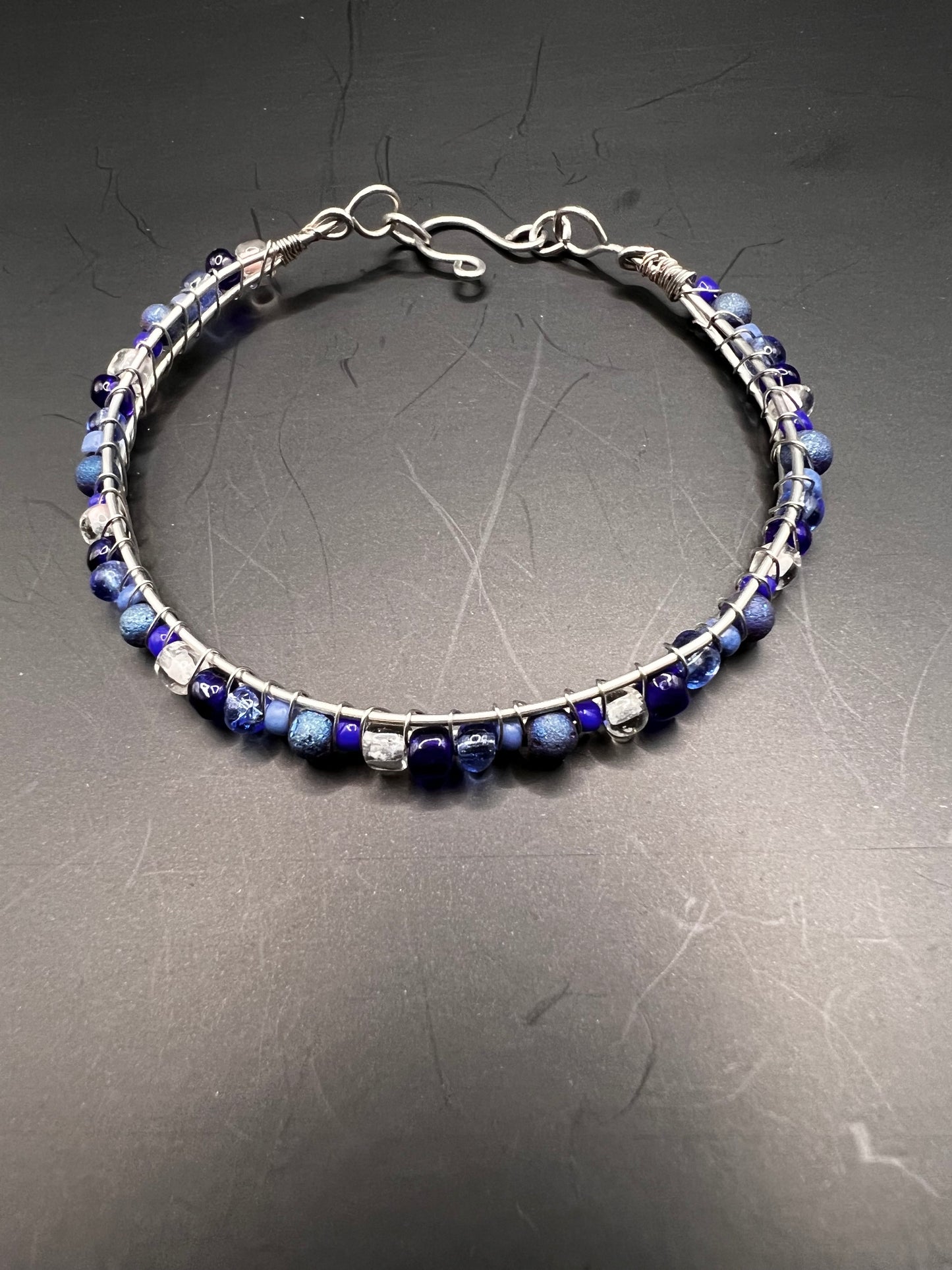 Silver cuff bracelet with wrapped various blue and white beads