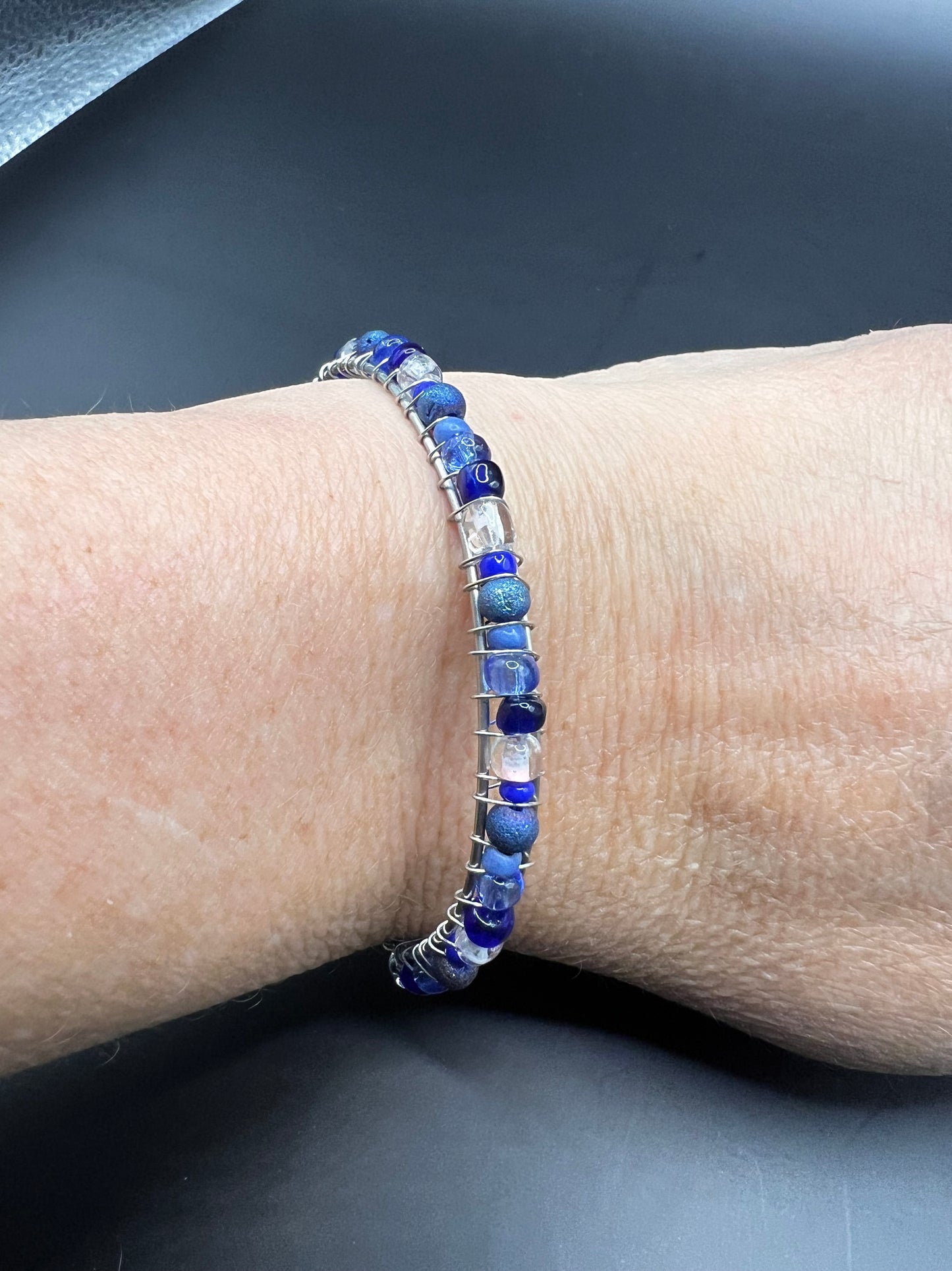 Silver cuff bracelet with wrapped various blue and white beads