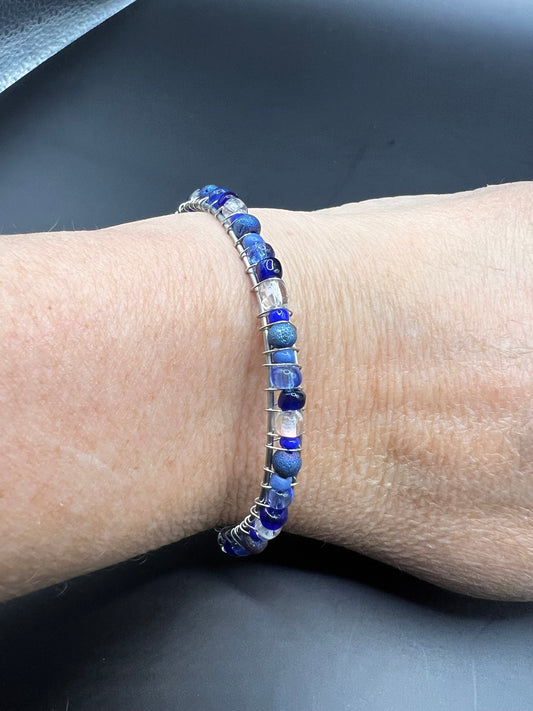 Silver cuff bracelet with wrapped various blue and white beads