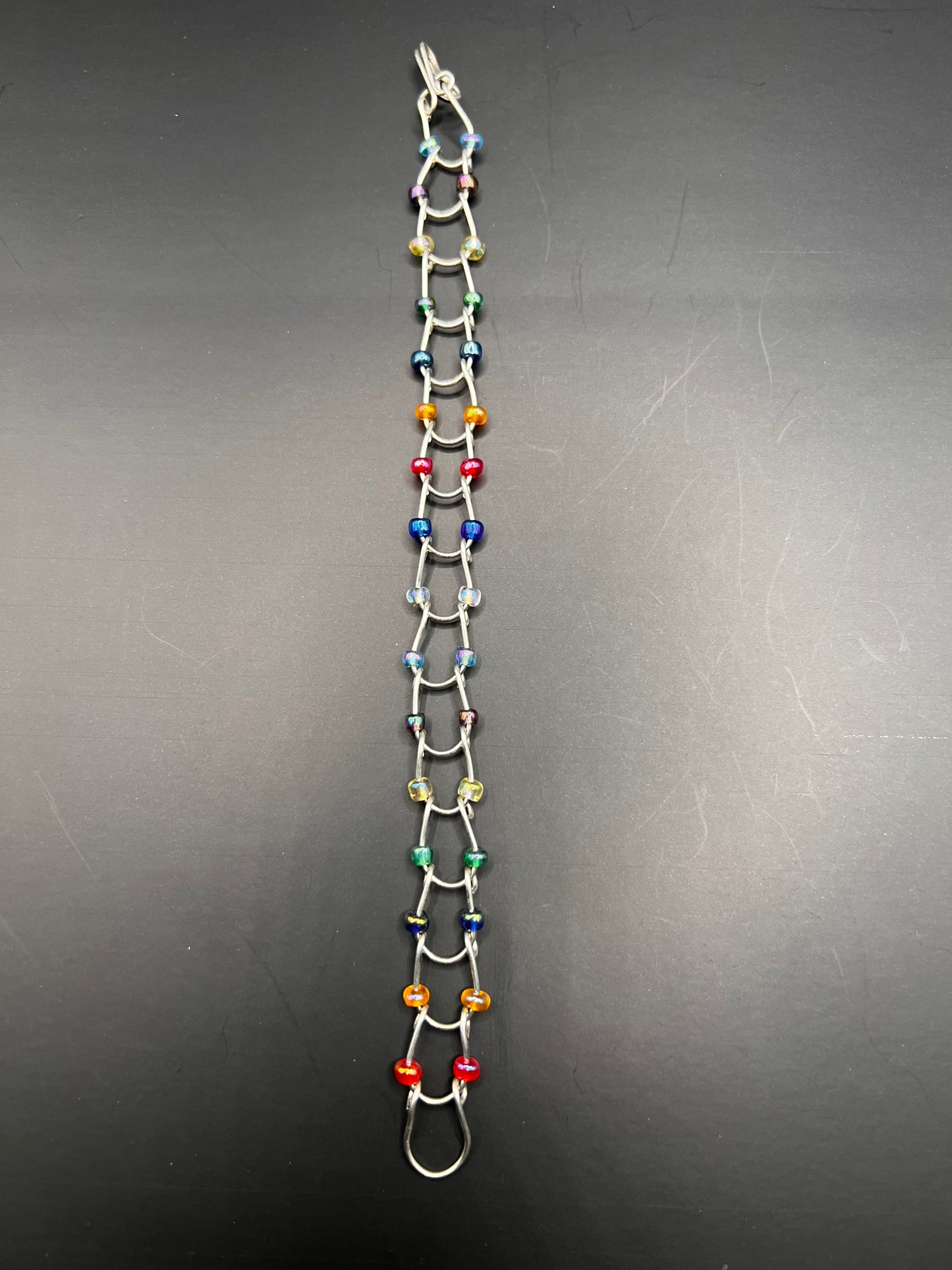 Silver bracelet with horseshoe shaped links with multicolored beads