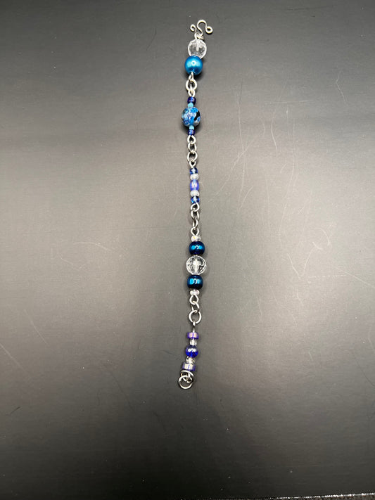 Silver bracelet with variety of sizes and colors of blue beads