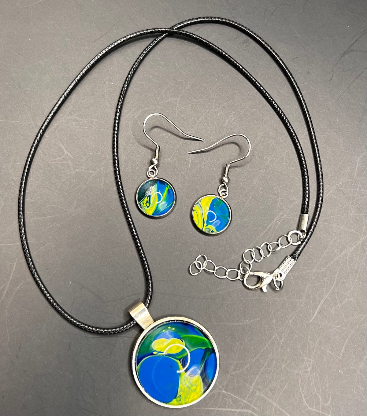 Blue & yellow round silver cabochon w/ black chord