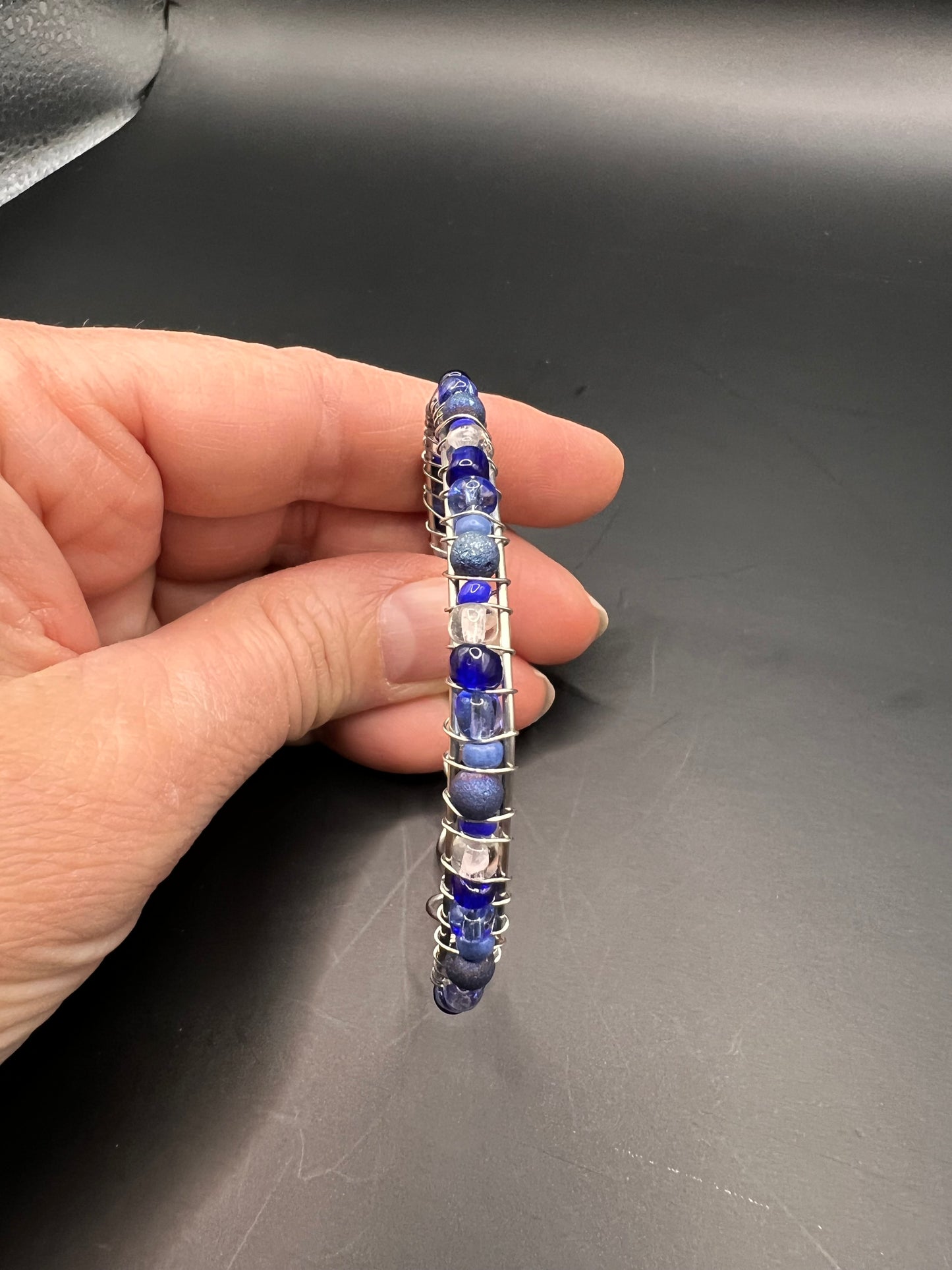 Silver cuff bracelet with wrapped various blue and white beads
