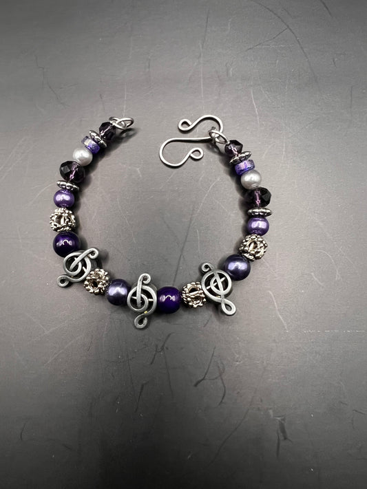 Silver cuff bracelet w/ purple beads & treble clef notes
