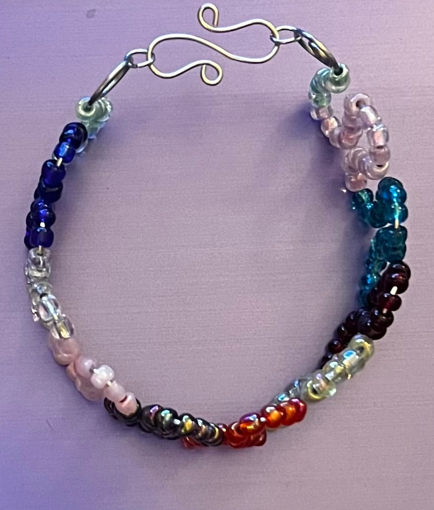 Multicolored loops w/ seed beads & coils. Cuffed silver bracelet